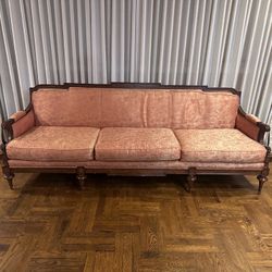 Antique Duncan Phyfe style sofa with a carved dark wood frame and pink upholstery