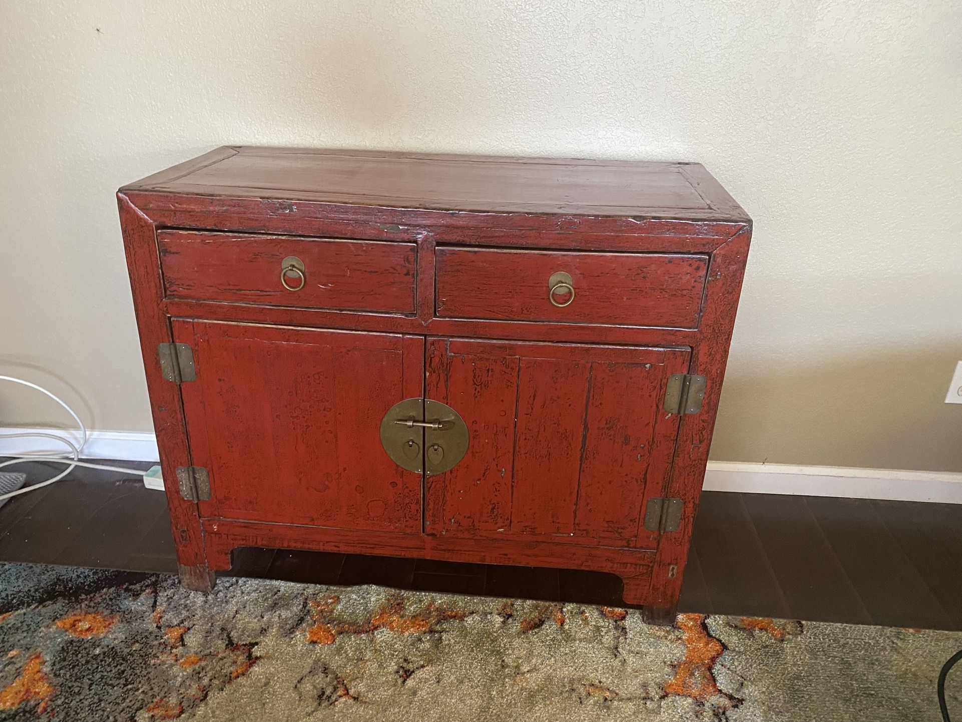 Antique Chinese Wooden Cabinet with a striking red lacquer finish and brass hardware.