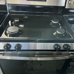 GE gas stove 4 burners and single oven In Black and stainless steel.