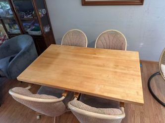 Maple wood dining table and 4 swivel chairs on wheels