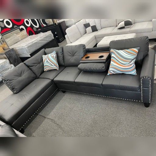 Black faux leather sectional sofa with drop down table