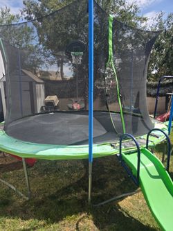 Trampoline with swings and a slide.