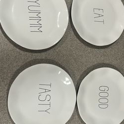 4-piece set of white ceramic plates from the Parini Cookware line, featuring the words "YUMMM", "EAT