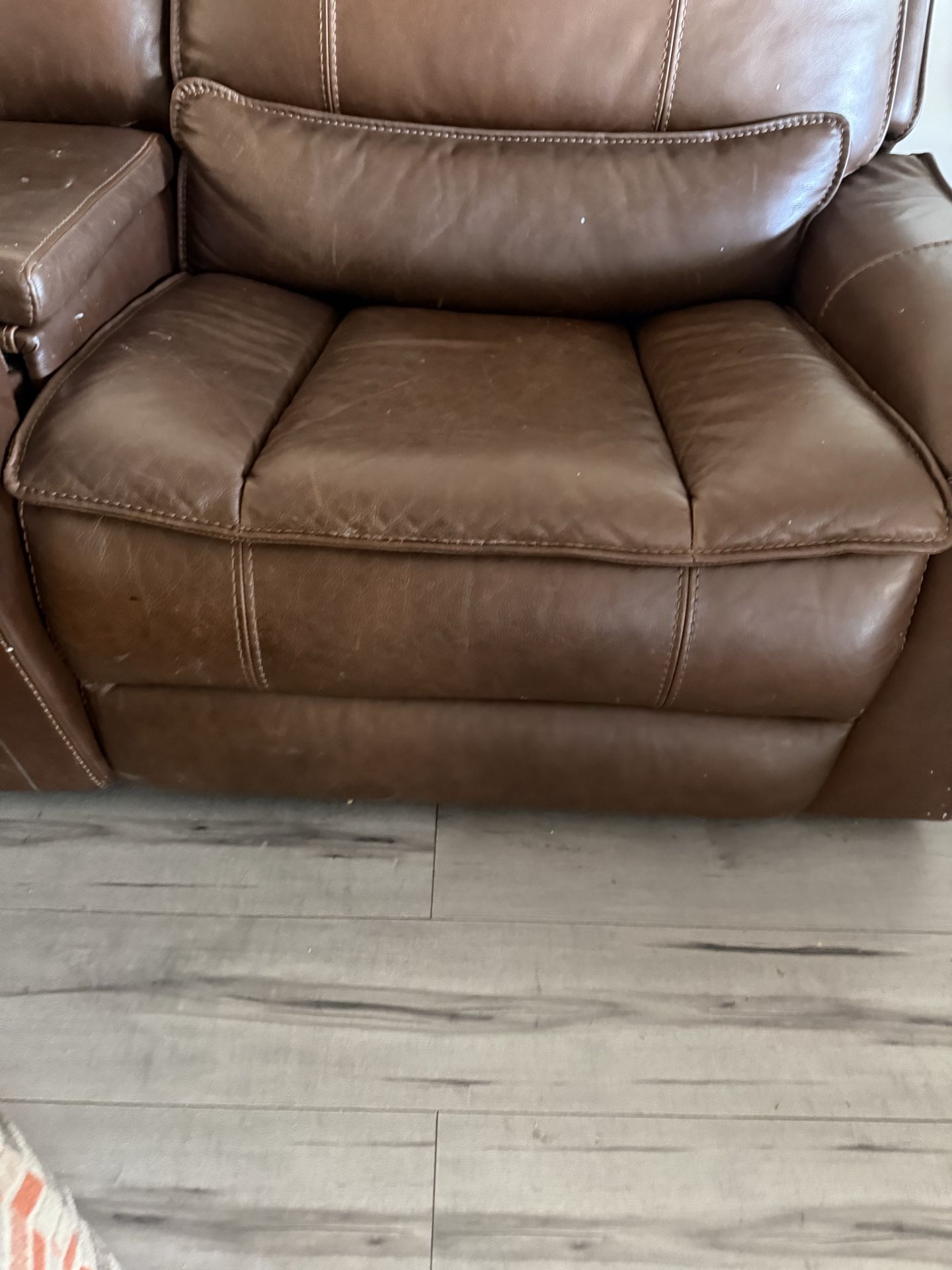The leather sofa set includes one extra piece—not an ottoman.
