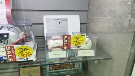 autographed baseballs from Kyle Harrison and Tom Murphy on sale in display cases