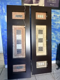 pair of decorative wood wall art panels featuring abstract, textured inserts.