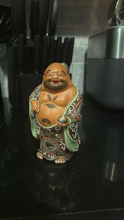 A Japanese Kutani porcelain figurine of the laughing Buddha Hotei.