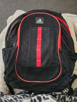 Lightweight mesh adidas backpack. Red trim and vertical red webbing detail. Multiple zip pockets for organization. Padded shoulder straps for comfort.