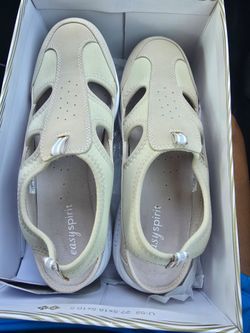 Easy Spirit casual sandals in a neutral beige tone. Cushioned footbed for comfort. Breathable cutouts for airflow. Slip-on style with secure back stra