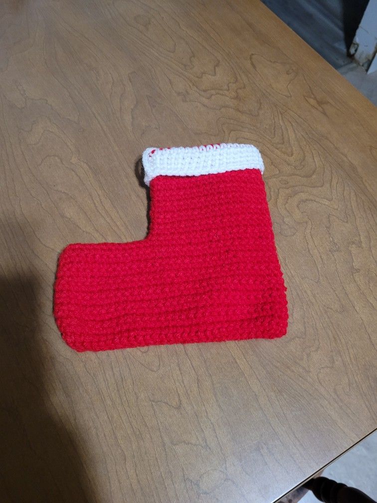 Handmade crochet Christmas stocking in red with a white cuff.
