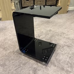 Black acrylic c-shape side table on wheels