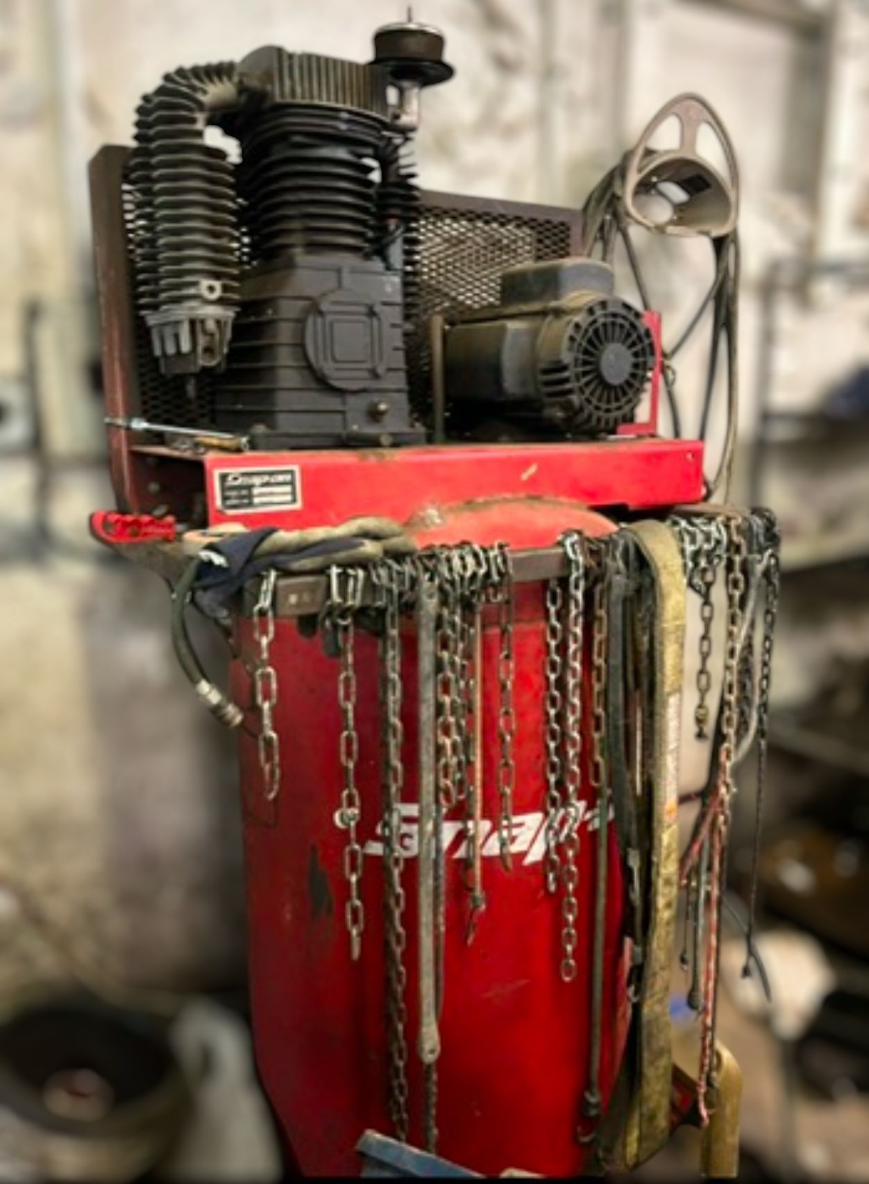 Snap-on 80-gallon vertical air compressor with chains hanging on it