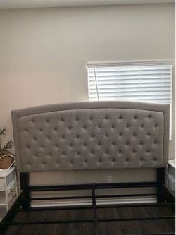 Grey tufted king size headboard and metal platform riser