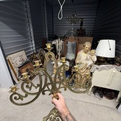 Ornate brass six-arm candelabra with scrollwork and grape motifs.