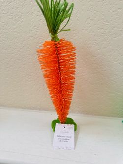 Ashland carrot tabletop décor is a vibrant orange bottle brush design with green paper foliage.