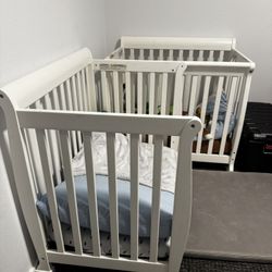Two White Delta Mini Cribs Twins