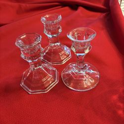 set of three clear glass taper candle holders. These items are designed to hold standard taper candles and feature a classic, turned shape with a hexa