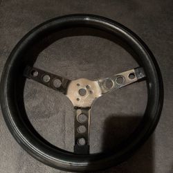 Black leather steering wheel with silver metal spokes