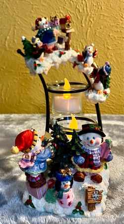 Holiday Time Sculpted Candle Garden Set Beautiful Christmas centerpiece set featuring a snow-covered house, a snowman, and two evergreen trees on a di