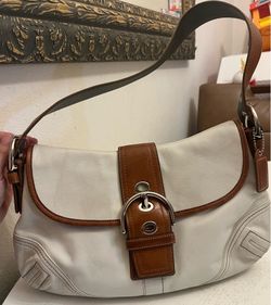 vintage white Coach Soho leather shoulder bag featuring a tan leather buckled strap and brown trim