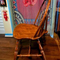 Antigue classic Windsor chair, specifically a hoop-back (or bow-back) side chair. A notable feature is its brace-back design