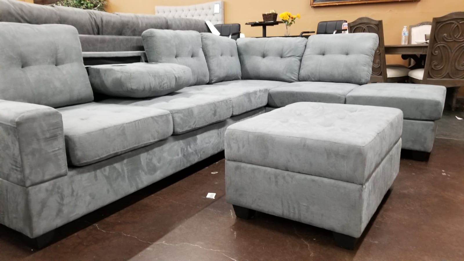 Gray Reversible Sectional with drop down console and a storage ottoman