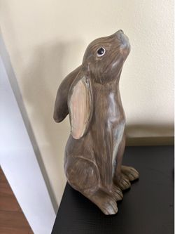 bunny figurine features a realistic brown wood carving texture