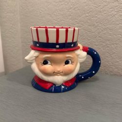 $12…New Adorable Uncle Sam mug in red, white & blue. Carnival Cottage by Joanna Parker and Magenta.  Measures 4.5” T x 6” W.   Please pickup in the ar
