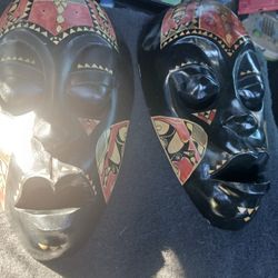 a pair of hand-carved Indonesian wooden tribal masks