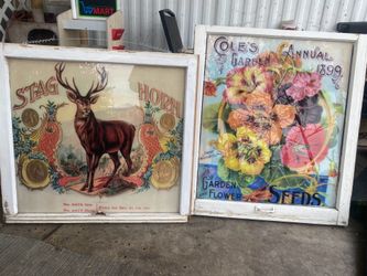 Vintage- style advertising prints mounted inside old wooden window frames, commonly used as rustic farmhouse wall decor.
