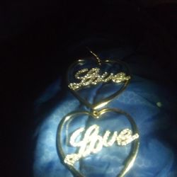 Gold Heart Shaped Hoops That Say Love With Stones Over Layed Word Love