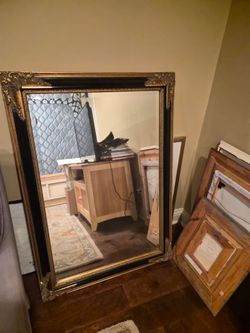 Beveled mirror with black and gold gilded frame