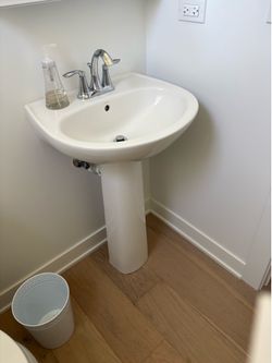 White pedestal sink with MOEN faucet