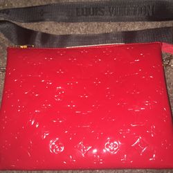 Crafted with the modern woman in mind, the LOUIS VUITTON Lexington Red Vernis monogram patent pouchette offers a touch of elegance and convenience. Th