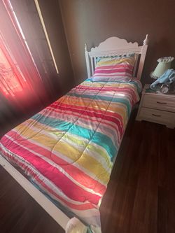 Twin bed with mattress and comforter