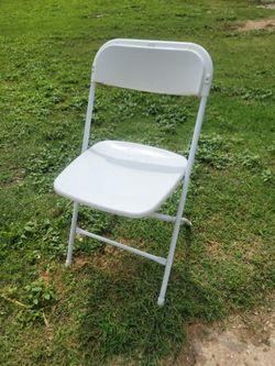 White plastic folding chairs with metal frame.