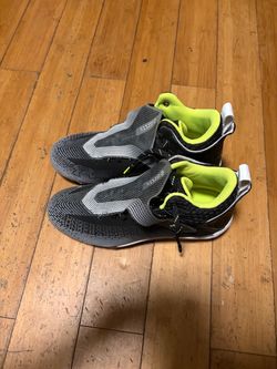 Size 10 Under Armour Highlight Hammer MC football cleats, featuring a black-and-gray gradient pattern with a bright neon yellow-green interior collar.