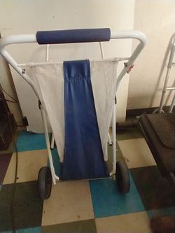 White foldable clothes hamper with mesh bag and wheels.