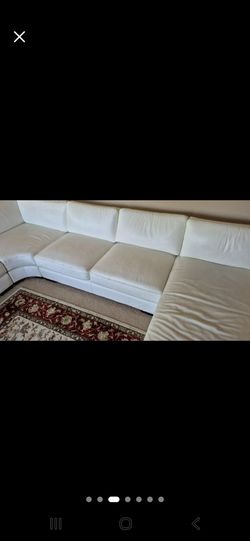 Modern white leather sectional sofa featuring a built-in glass panel and coffee table