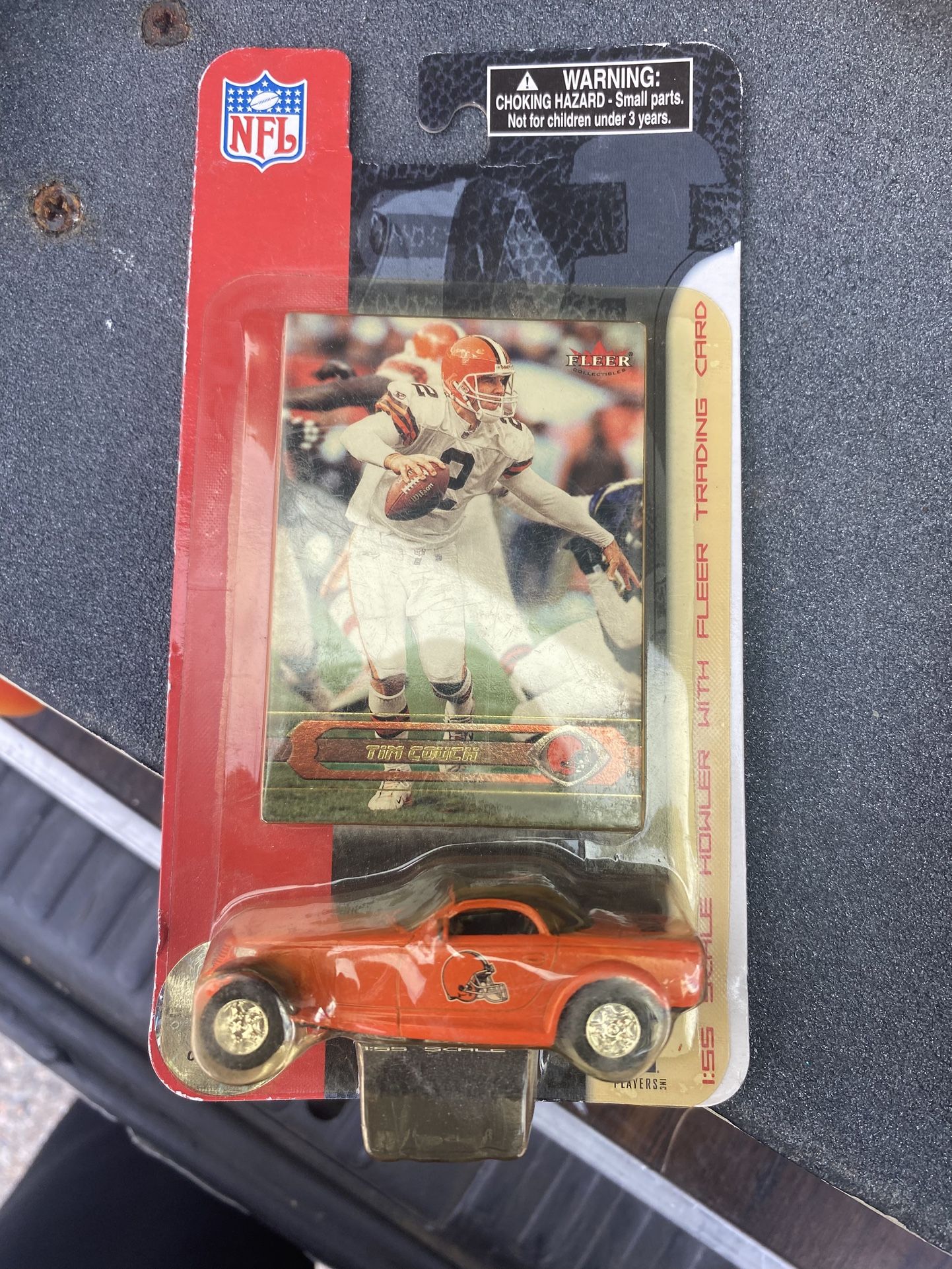 Tim Couch Fleer football trading card and a toy car.