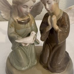 vintage porcelain figurine featuring two kneeling figures, often identified as angels or children