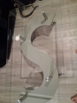Glass coffee table with modern s shaped center shelf with metal legs