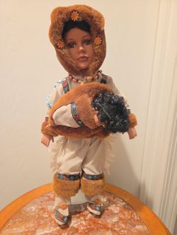 Native porcelain doll in parka with baby