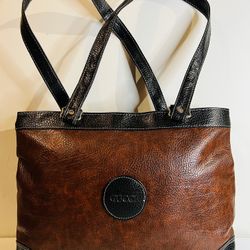 Fashionable brown bag with black handles.