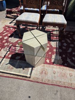The 1970s Artedi coffee table features a hexagonal travertine base and brass supports.