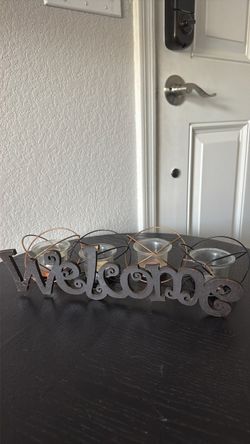 4 candle holders and welcome sign.