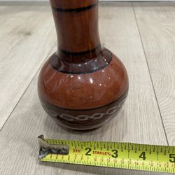 Vintage ceramic vase featuring Native American reddish-orange tones and black decorative line work.
