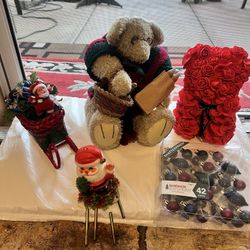 Celebrate the season with this charming holiday decor set featuring a plush teddy bear and Santa figurine. The teddy bear is dressed in festive red an