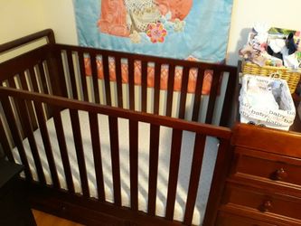 Crib converted to toddler bed with changing table draws