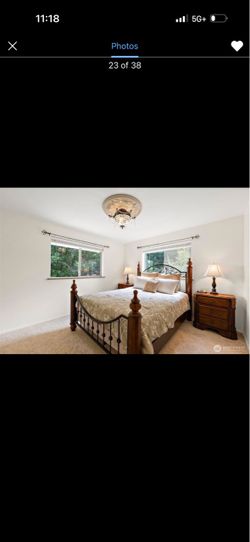 bed frame with decorative metal scroll headboard panels and matching nightstands.